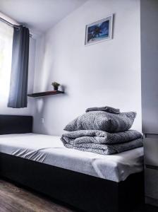 - une chambre avec un lit et une pile de couvertures dans l'établissement Pokoje Gościnne Sterowa 5, à Władysławowo