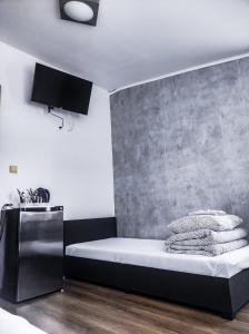 - une chambre avec un lit et un mur en béton dans l'établissement Pokoje Gościnne Sterowa 5, à Władysławowo