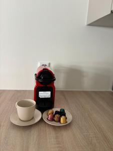 a cup and a plate of food and a coffee maker at Central apartment in Luxembourg City Center -Parking in Luxembourg