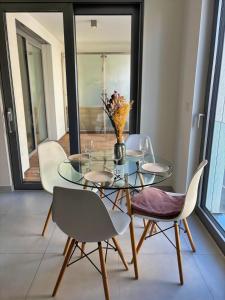 a glass table with chairs and a vase with flowers at Central apartment in Luxembourg City Center -Parking in Luxembourg