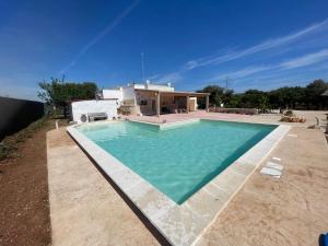a swimming pool in front of a house at Trullo Del Salento in San Vito dei Normanni