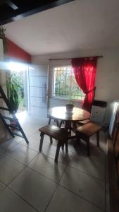 une pièce avec une table, des bancs et une fenêtre dans l'établissement LOFT Huayna picchu, à La Falda 4 autres photos