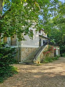 a building with stairs in front of a house at L'ile Des Prevots in Crosne