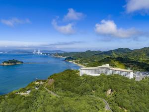 Grand Mercure Awaji Island Resort & Spa في Minamiawaji: اطلالة جوية لمنتجع على تل بجوار المحيط