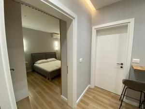 1 dormitorio con 1 cama y una puerta que conduce a una habitación en Bliss Apartment - Luxury and Cosy, en Berat