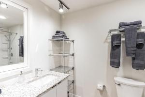 a white bathroom with a sink and a mirror at Urban Elegance Studio Oasis Prime Location in Cleveland