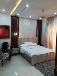 a bedroom with a large bed and a table at Maskan in Islamabad