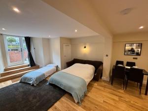 a bedroom with two beds and a table in it at Minster Bells Suite in York