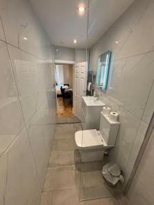 a white bathroom with a toilet and a sink at Minster Bells Suite in York