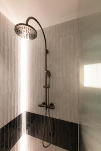 La salle de bains est pourvue d'une douche avec un pommeau de douche. dans l'établissement Gentle Hide Designhotel, à Salzbourg