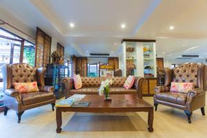 
a living room filled with furniture and a large window at Nak Nakara Hotel-SHA Extra Plus in Chiang Rai
