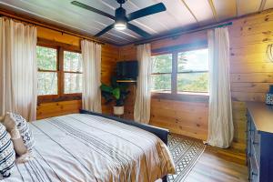 a bedroom with wooden walls and a bed with a ceiling at Hawk Hollow in Ellijay