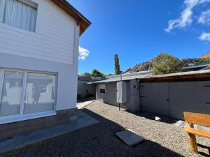 a house with a bench next to a building at MAITEN Esquel in Esquel +2 photos
