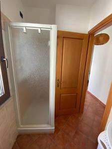 una ducha con puerta de cristal en un baño en Salt Whisper - Salt Whisper - Bilocale con terrazzi e piscina, en La Caletta