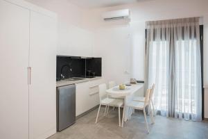 Una cocina blanca con una mesa y sillas blancas. en Pasiphae Suite the sense of luxury, en Heraclión 24 fotos más