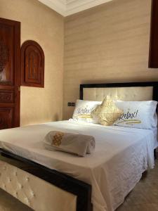 sypialnia z łóżkiem z białymi prześcieradłami i poduszkami w obiekcie Riad les fleurs de Lys de Al qaria Assiyahia w Marakeszu