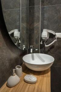 Un baño con un lavabo blanco y un espejo. en Pasiphae Suite the sense of luxury, en Heraclión
