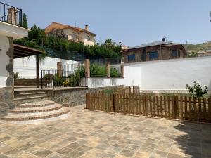 ein Haus mit einem Holzzaun und einer Treppe in der Unterkunft Cortijo Los Pinillos in Pinos Genil