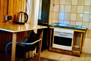 a kitchen with a stove and a table and a chair at u6 Schöpfwerk hostel 002 in Vienna