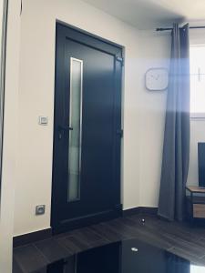 a black door in a room with a window at Studio, Maison, rez de chaussée, Perpignan in Perpignan