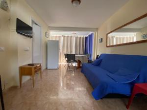 a living room with a blue couch and a table at STUDIO Gerona Playmon Virginia in Benidorm