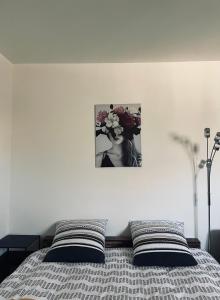 łóżko z dwoma poduszkami i zdjęciem na ścianie w obiekcie Studio, Maison, rez de chaussée, Perpignan w Perpignanie