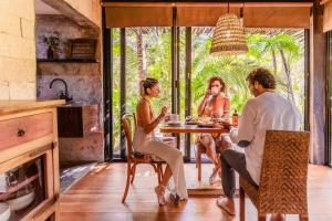 a group of people sitting around a table in a kitchen at Vida Silvestre in Tulum