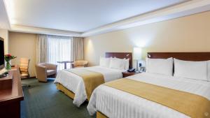 En eller flere senge i et værelse på GHL Hotel Capital