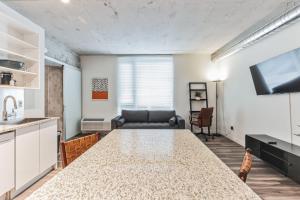 Una cocina y una sala de estar con una mesa y un sofá. en Sleek downtown Cleveland apartment, en Cleveland 9 fotos más
