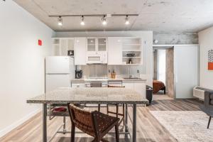 Una cocina con gabinetes blancos y una mesa y sillas. en Sleek downtown Cleveland apartment, en Cleveland
