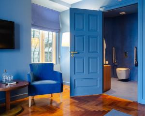 a blue room with a blue door and a chair at Villa Cascais Boutique Hotel in Cascais
