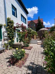 een tuin met bloemen voor een gebouw bij Ferienwohnung TINA in Naumburg