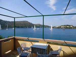 a table and chairs on a balcony with a view of the water at Apartments More in Skrivena Luka