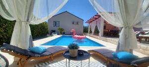 a swimming pool with a pink swan in a backyard at House Matenda house in Solin