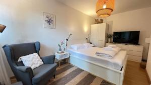een slaapkamer met een bed, een stoel en een tv bij Izola Dreamy Stays KORD in Izola