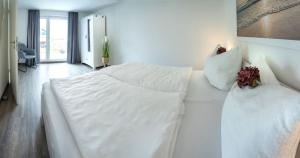 Una cama blanca y un sofá en una habitación. en Wasserblick Loddin Comfort 6, en Loddin