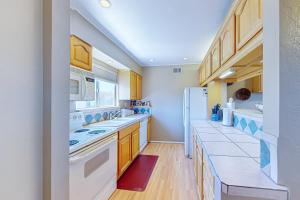 a kitchen with white appliances and wooden cabinets at Cozy Hideout in Scottsdale
