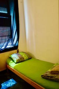 a small bed in a room with a window at U6 Schöpfwerk Hostel 1 in Vienna
