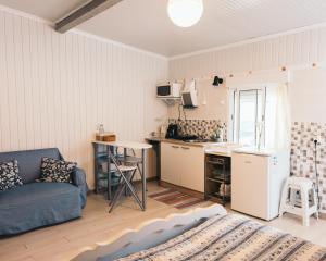 a living room with a couch and a kitchen at Costanova Surfhouse in Ílhavo