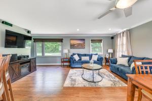 a living room with blue couches and a table at Dock, Kayaks, Game Room Lakefront Antioch Home! in Antioch