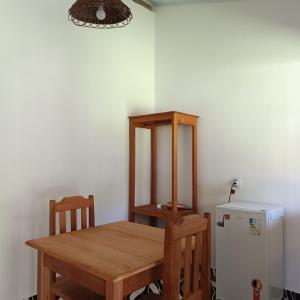 a dining room with a table and a refrigerator at Pousada Pedra do Negro in Caraíva