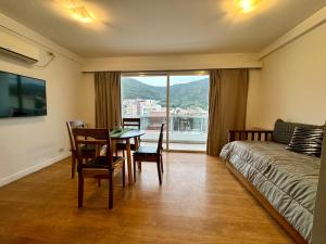 a living room with a table and a bed and a window at Augusto Apart 3 in Salta