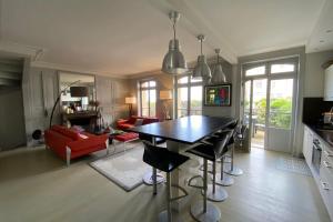 een keuken en een woonkamer met een tafel en stoelen bij House with sea view in the Hypercentre in Trouville-sur-Mer