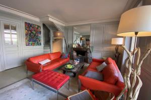 uma sala de estar com dois sofás vermelhos e uma mesa em House with sea view in the Hypercentre em Trouville-sur-Mer