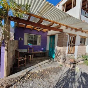 a purple house with a wooden pergola at Casa La Molina in Tilcara