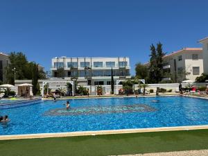a large swimming pool with people in the water at Cosy apartment at Mythical Sands resort in Paralimni