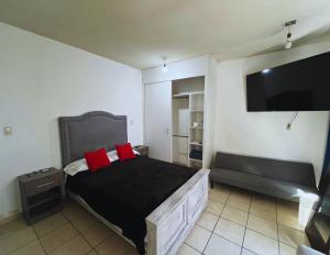 a bedroom with a bed with red pillows and a flat screen tv at 10 VENATOR House Boutique in León