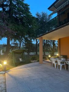 un patio con tavoli, sedie e griglia di Casa Isore con 3 camere da letto a Pesaro