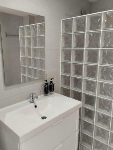 Baño blanco con lavabo y espejo en Pueblo Evita Hill en Benalmádena