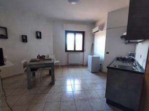 uma cozinha com uma mesa e uma pequena mesa e uma janela em Alloggio Alfa em Civitavecchia